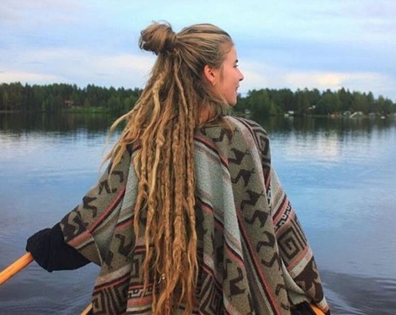 Gather the top half of your loose hair into a bun or top knot and leave the dreadlocks flowing freely. (Source: Pinterest)