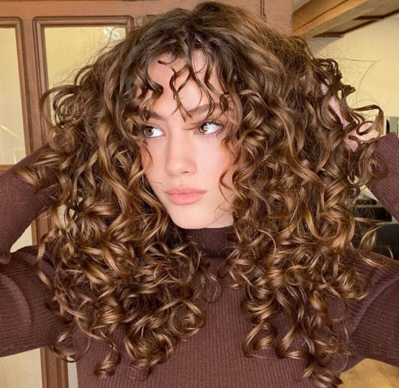 If you have curly hair, you might have got interested in the idea of trying out curtain bangs. (Source: Zohna)