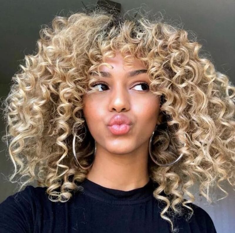 This combination of coiled curls and curtain bangs adds a touch of elegance. (Source: POPSUGAR)