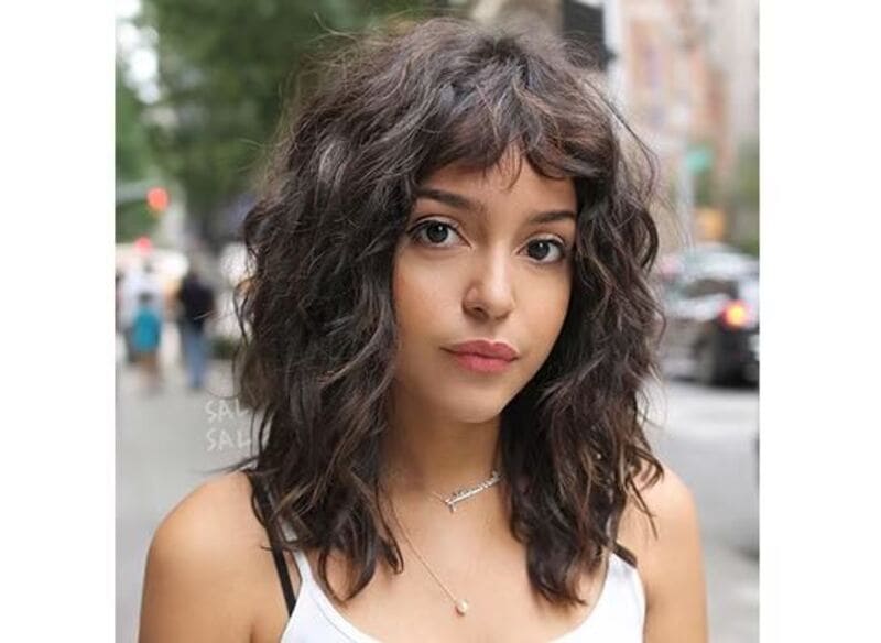 Short curtain bangs on curly hair is a delightful combination of curly texture and modern edge. (Source: Thptnganamst.edu.vn)