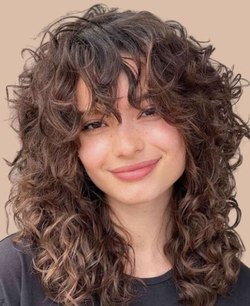 Layered curls and curly fringe is a versatile and eye-catching style for those with curly hair. (Source: The Mestiza Muse)