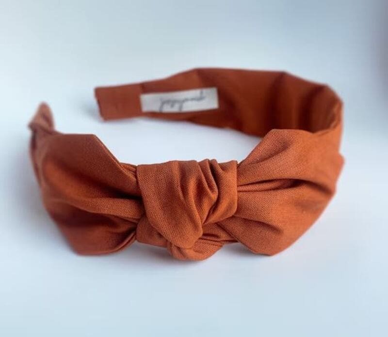 One great way to wear a fabric headband is by slipping it over an updo to hide thinning areas around the hairline. (Source: Etsy)