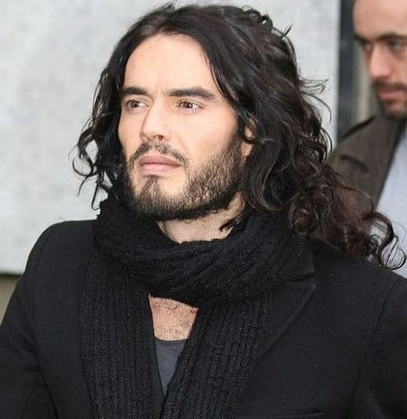 Russell Edward Brand typically sports shoulder-length curly hair in black or brown. (Source: Pinterest)