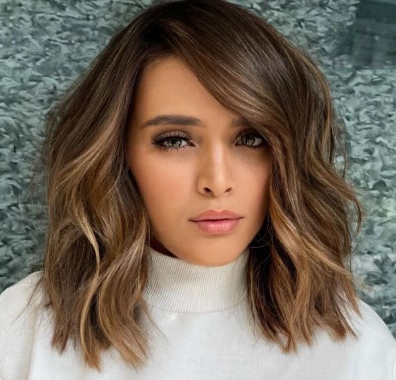 The side-swept wavy lob can capture the relaxed and casual vibe of a lazy day. (Source: Hair Adviser)