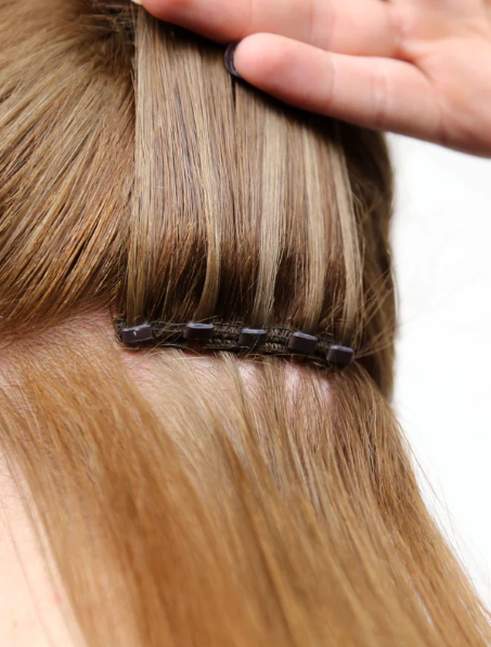 The "weft" method involves attaching a row of hair using small silicone-lined beads to the client's natural hair. (Source: Perfect Locks)