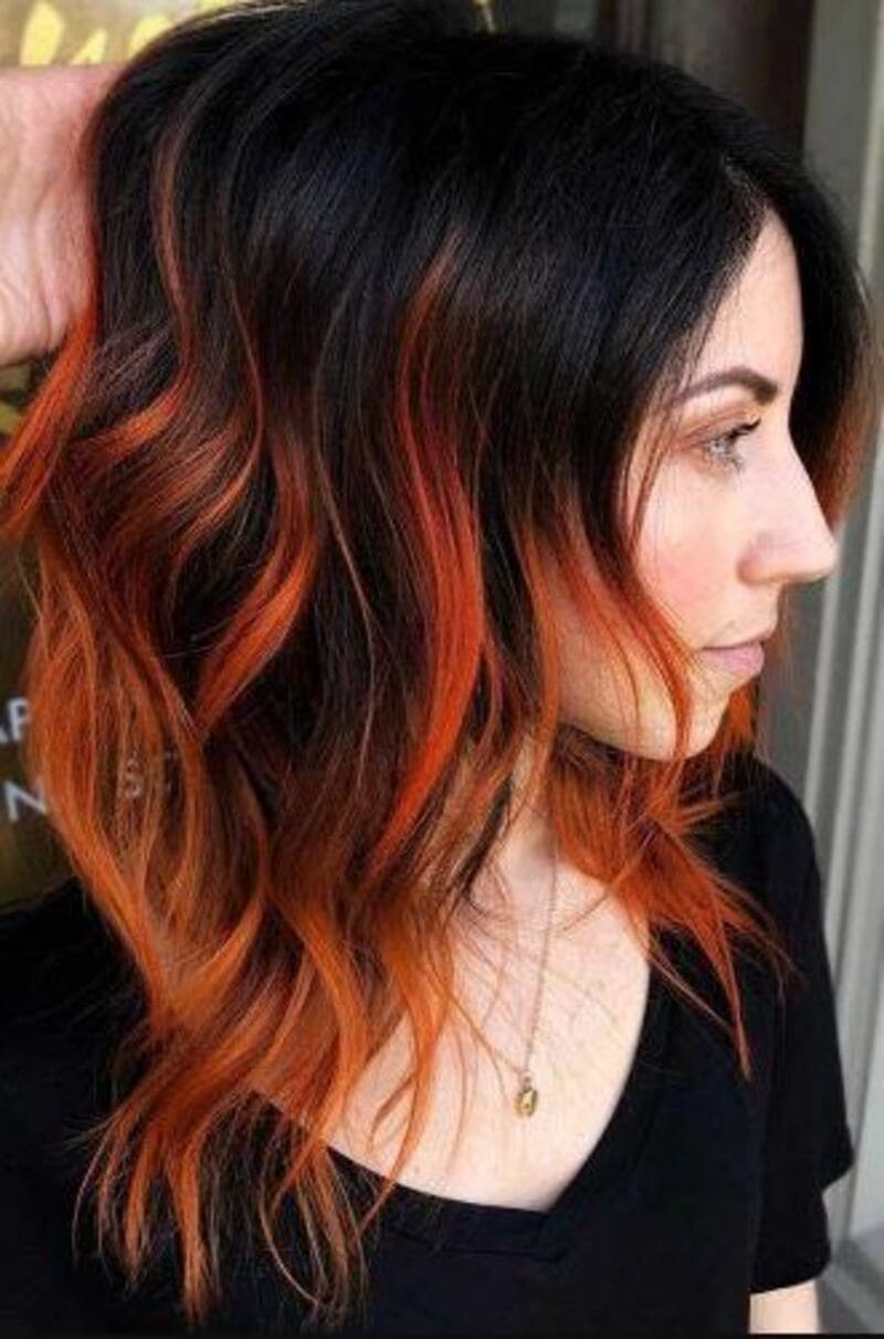 With orange roots seamlessly blending into black strands, your hair will exude an intriguing allure. (Source: Pinterest)