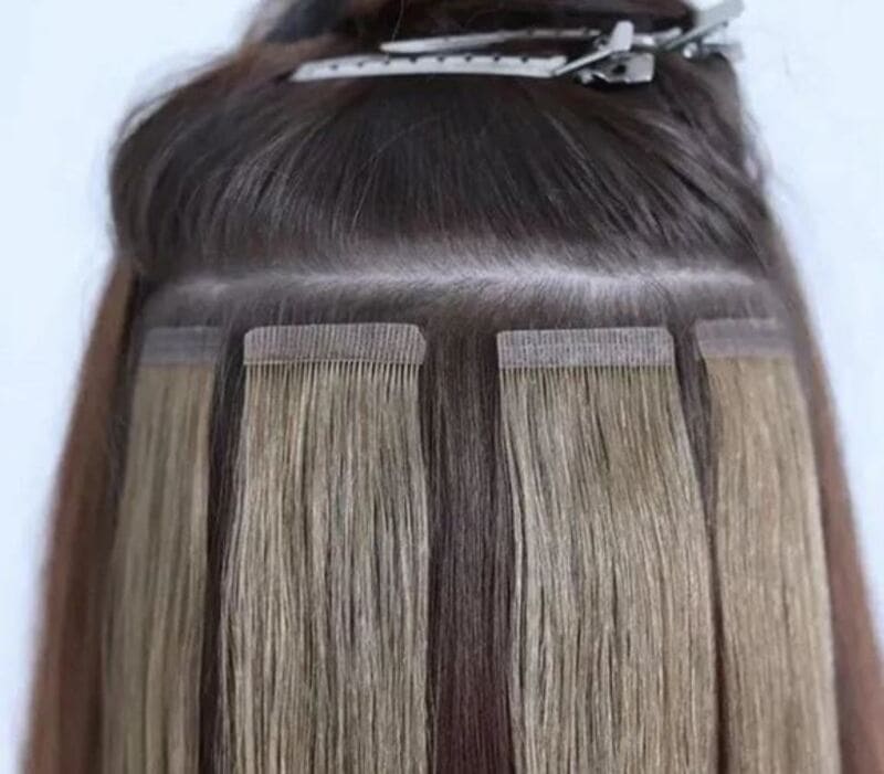 Tape in extensions stick to your hair using a thin layer of medical-grade glue. (Source: Lash You Train You)