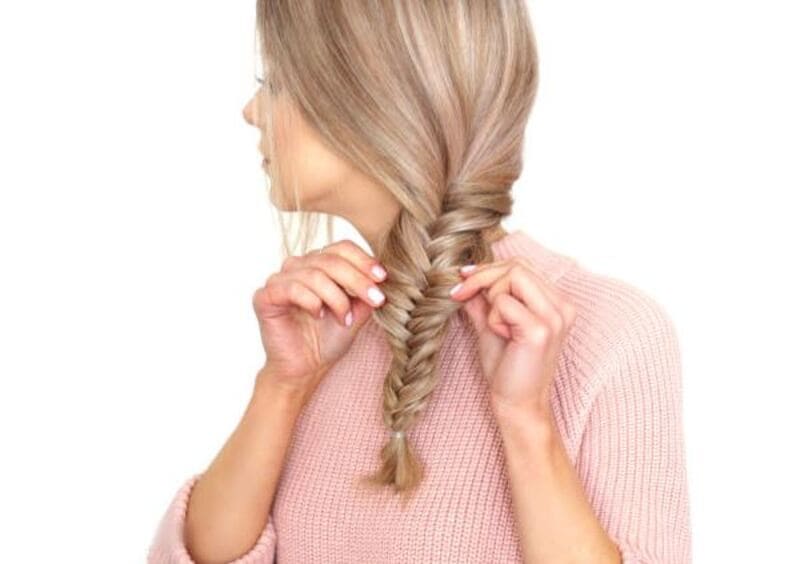 Pulling sections of your braid apart to loosen it to achieve the relaxed bohemian look. (Source: Yahoo News)